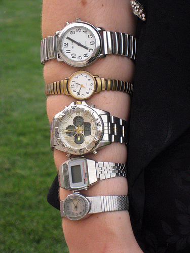 An arm with several wristwatches on it.